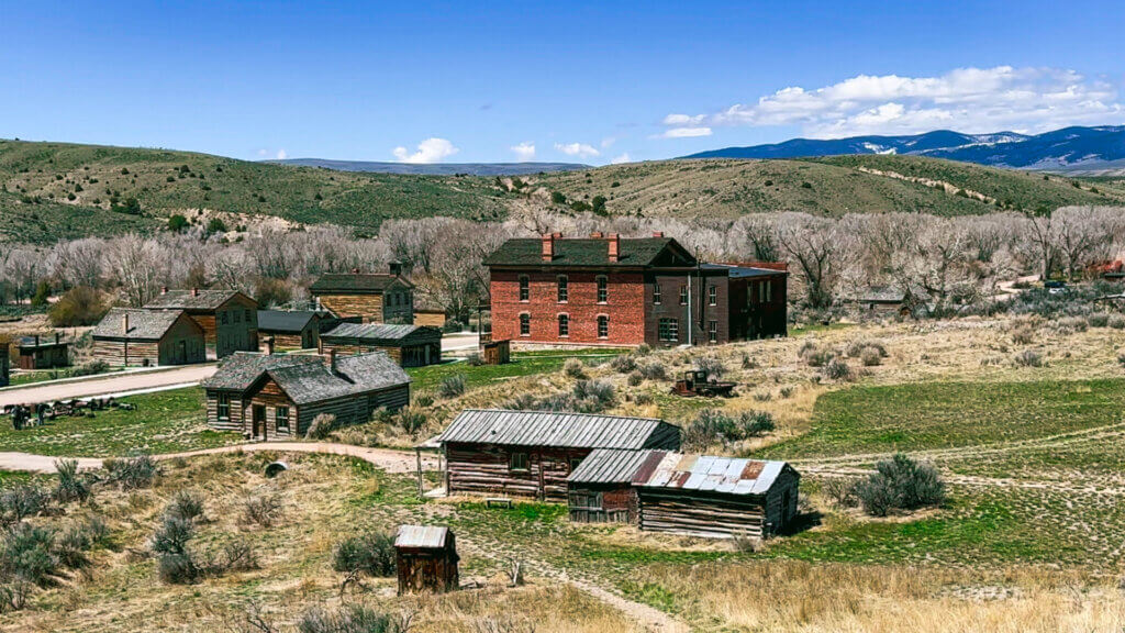 The buildings of Bannack an old mining ghost town stand out against Montana's landscape.